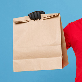 food delivery person holding a brown paper bag