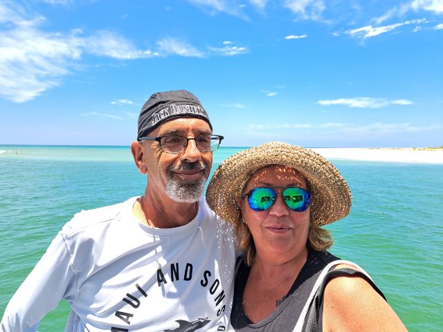 a man and woman wearing hats with the ocean in the background